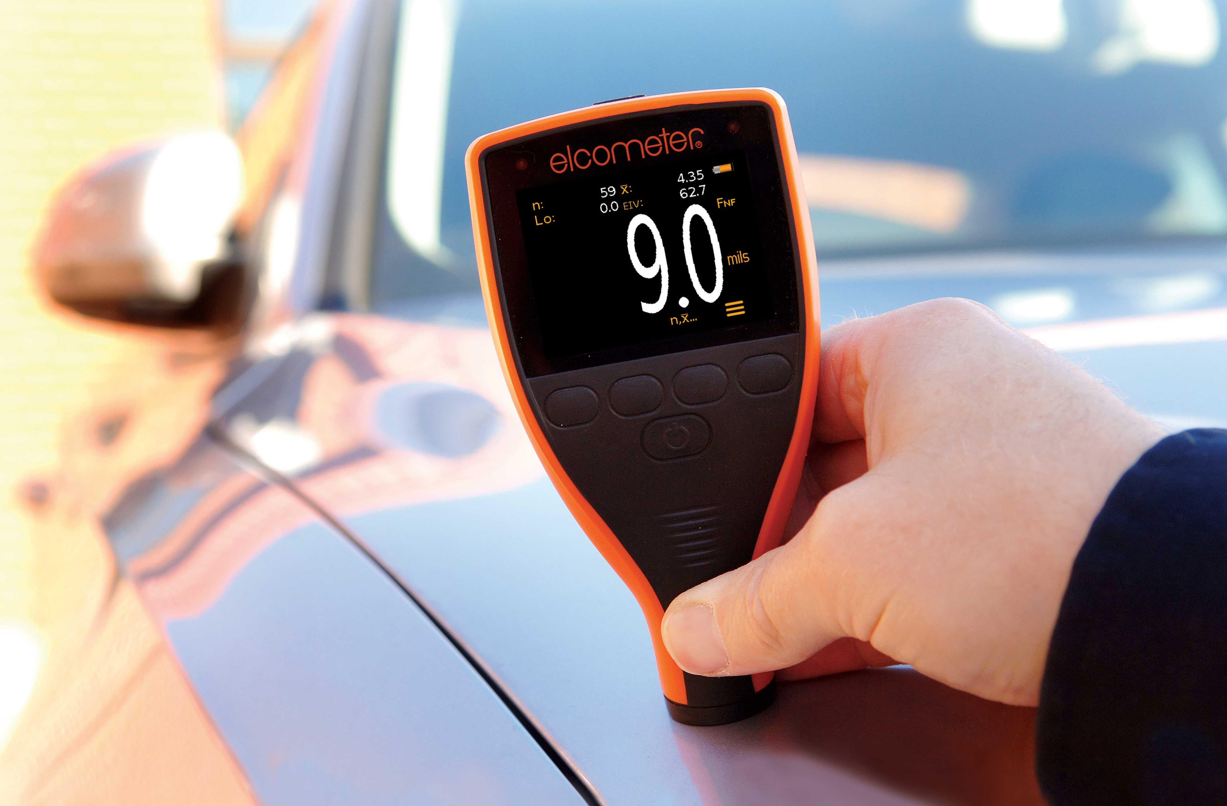 A Coating Inspector holding the Elcometer 311 Automotive Paint Meter on top of a vehicle to measure the paint thickness.